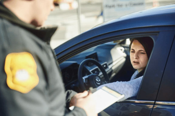 traffic officer issuing a ticket to a female civilian at a roadblock