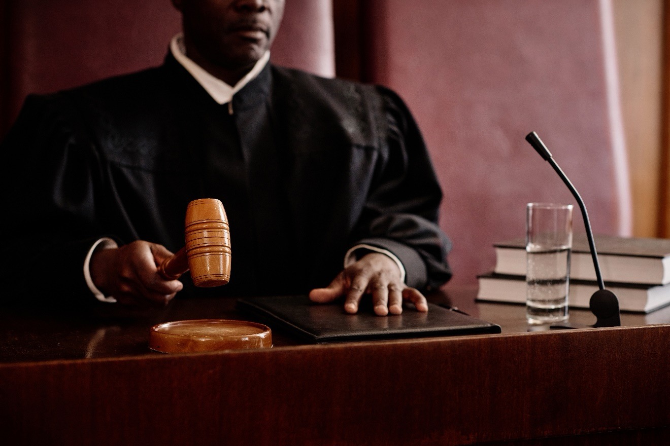 A judge seated at a desk holding a gavel